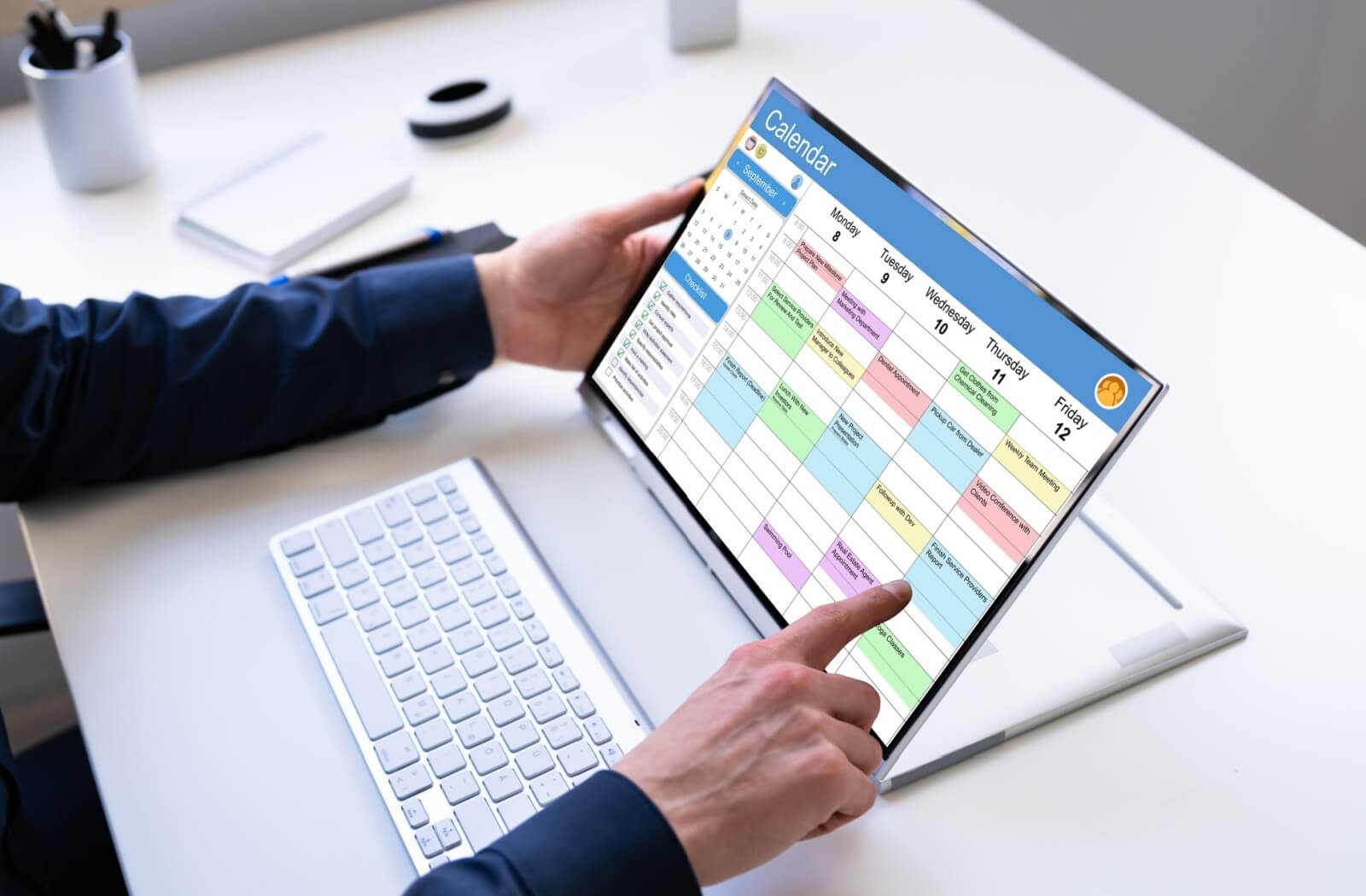 Someone books their regular dental cleaning on a tablet device, a sleek, wireless keyboard in front.